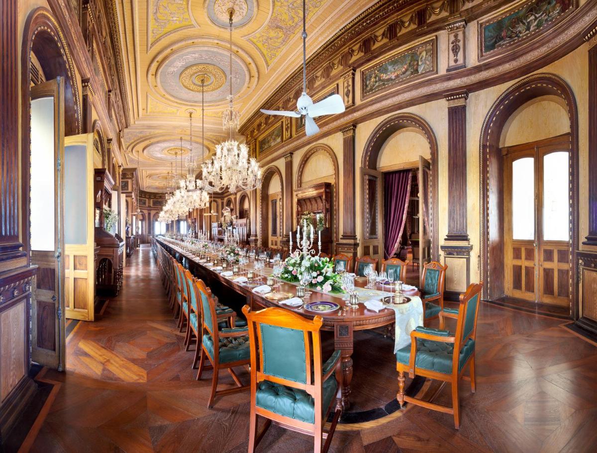 a long dining room with a long table and chairs at Taj Falaknuma Palace in Hyderabad a long dining room with a long table and chairs at Taj Falaknuma Palace in Hyderabad