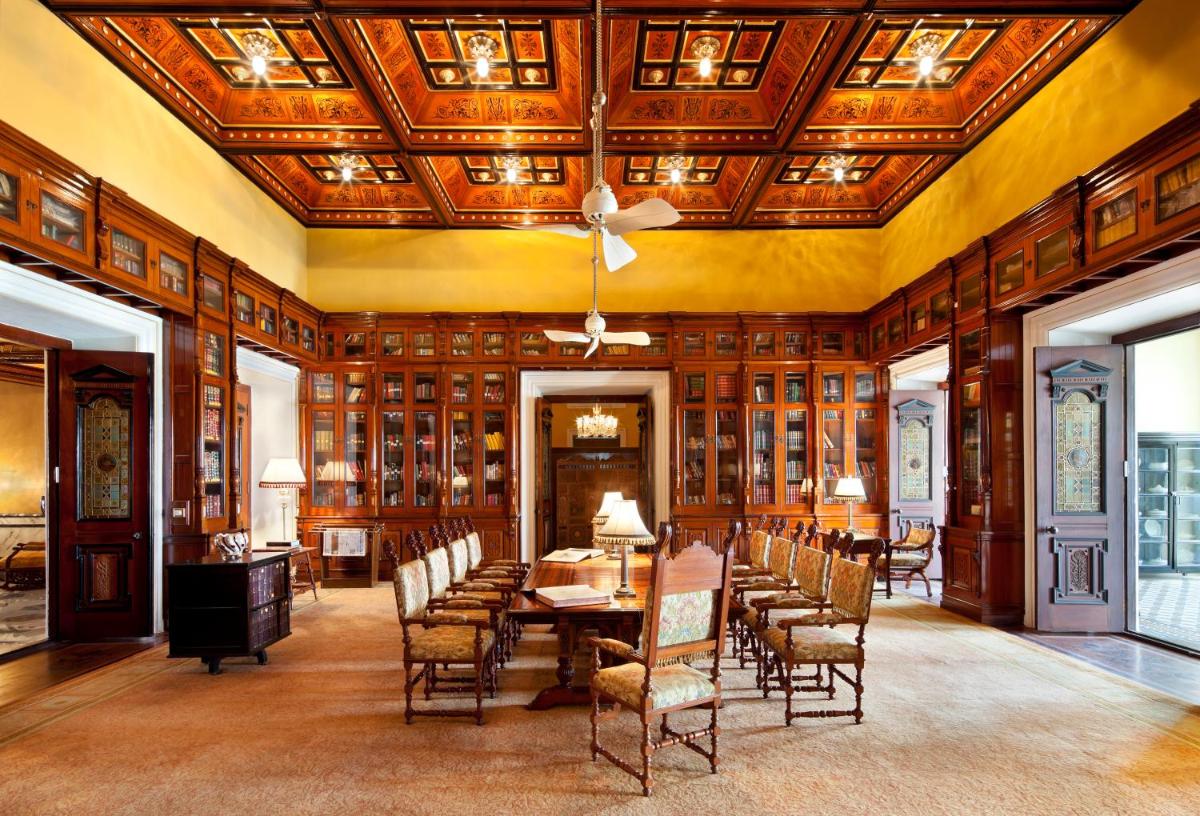 a dining room with a table and chairs and a ceiling at Taj Falaknuma Palace in Hyderabad
