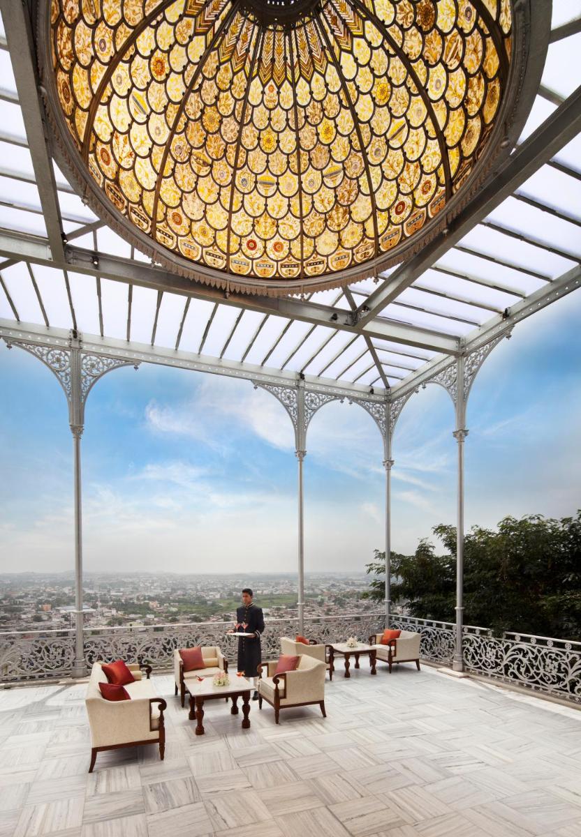 a man standing on top of a building with a chandelier at Taj Falaknuma Palace in Hyderabad