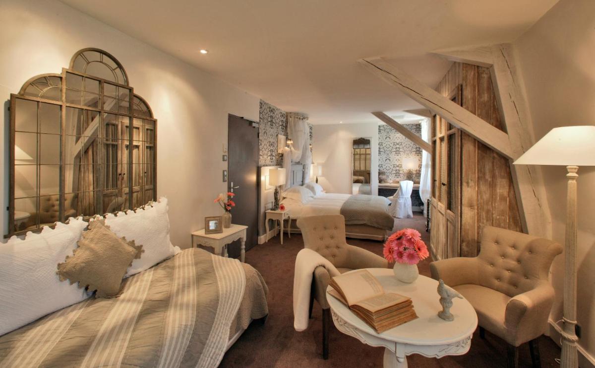 - une chambre avec un lit, une table et deux lits dans l'établissement Les Glycines - Hôtel & Spa - Teritoria, à Les Eyzies-de-Tayac