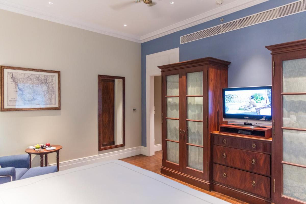a living room with a tv and a bedroom at Taj Connemara, Chennai in Chennai