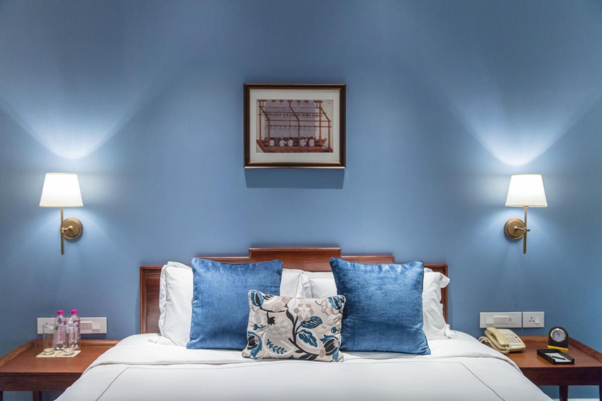 a blue bedroom with a bed with blue walls at Taj Connemara, Chennai in Chennai