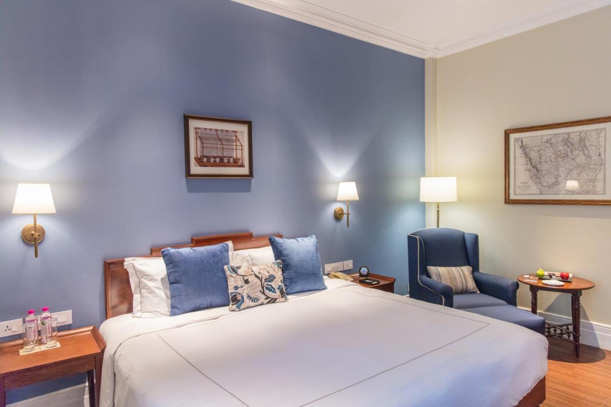 a bedroom with a large bed and a blue wall at Taj Connemara, Chennai in Chennai