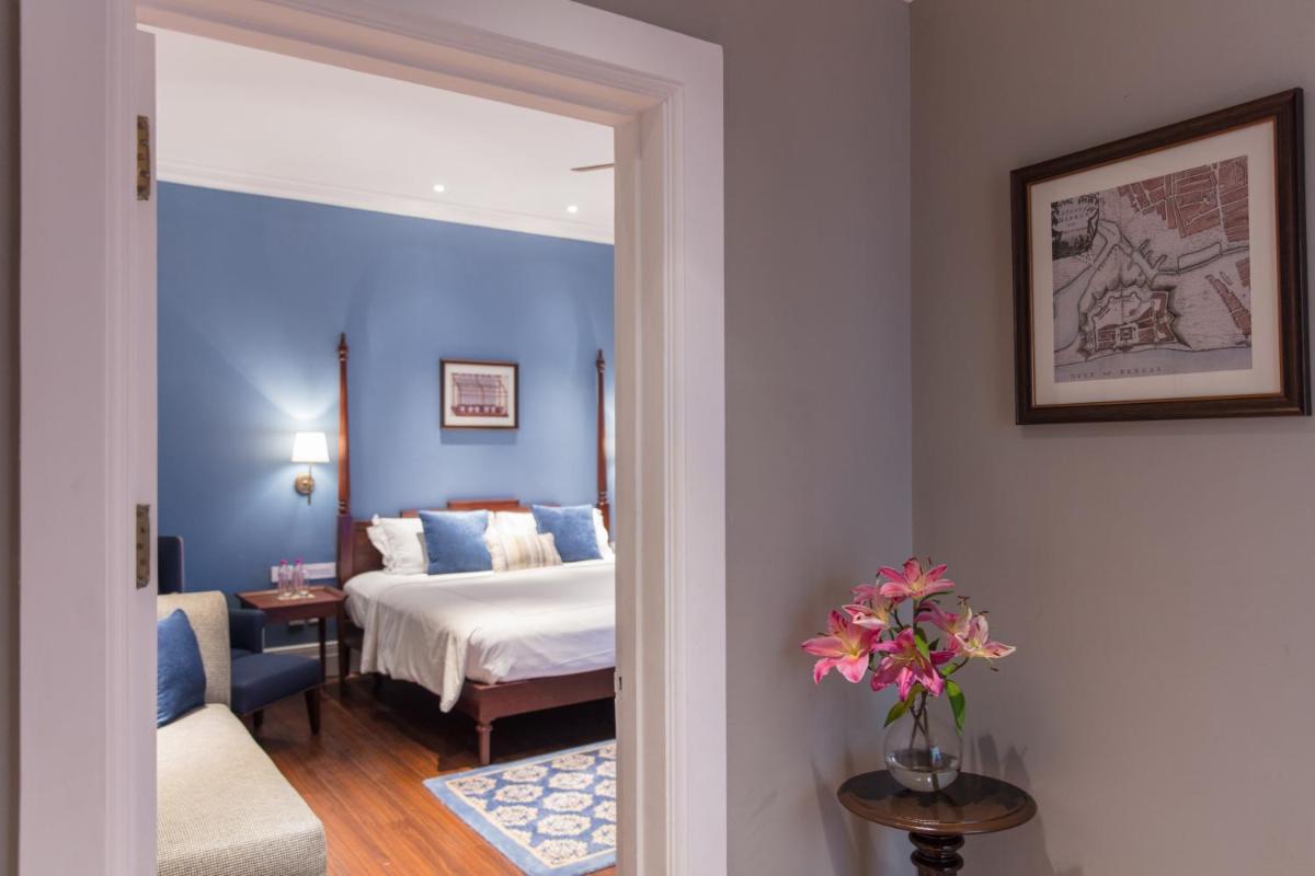 a hotel room with a bed and a vase of flowers at Taj Connemara, Chennai in Chennai