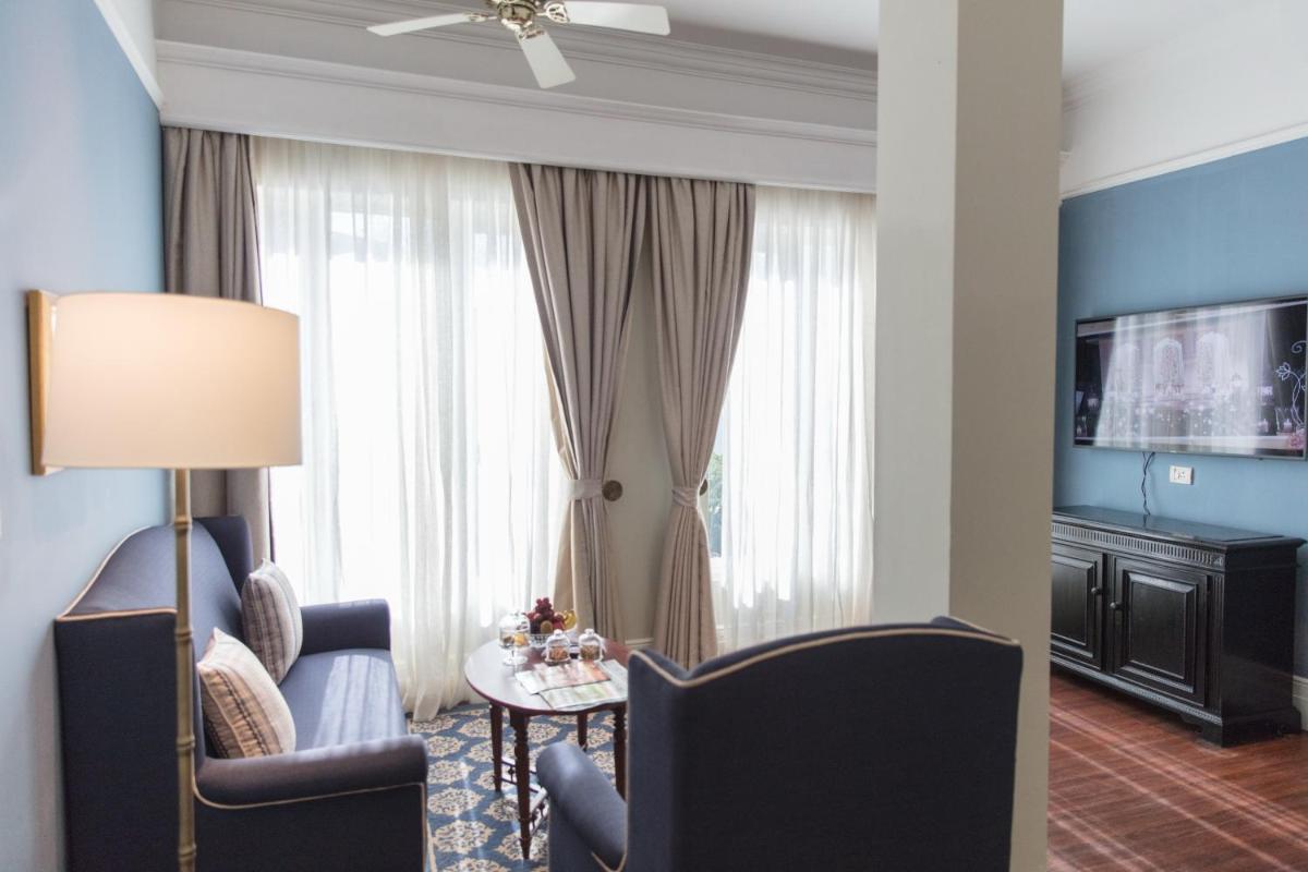 a living room with a couch and chairs and a television at Taj Connemara, Chennai in Chennai
