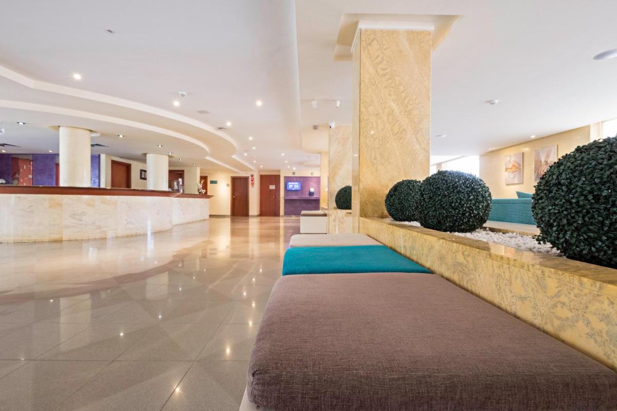 un vestíbulo de un hotel con una fila de plantas en azuLine Hotel Bahamas y Bahamas II, en El Arenal 37 fotos más
