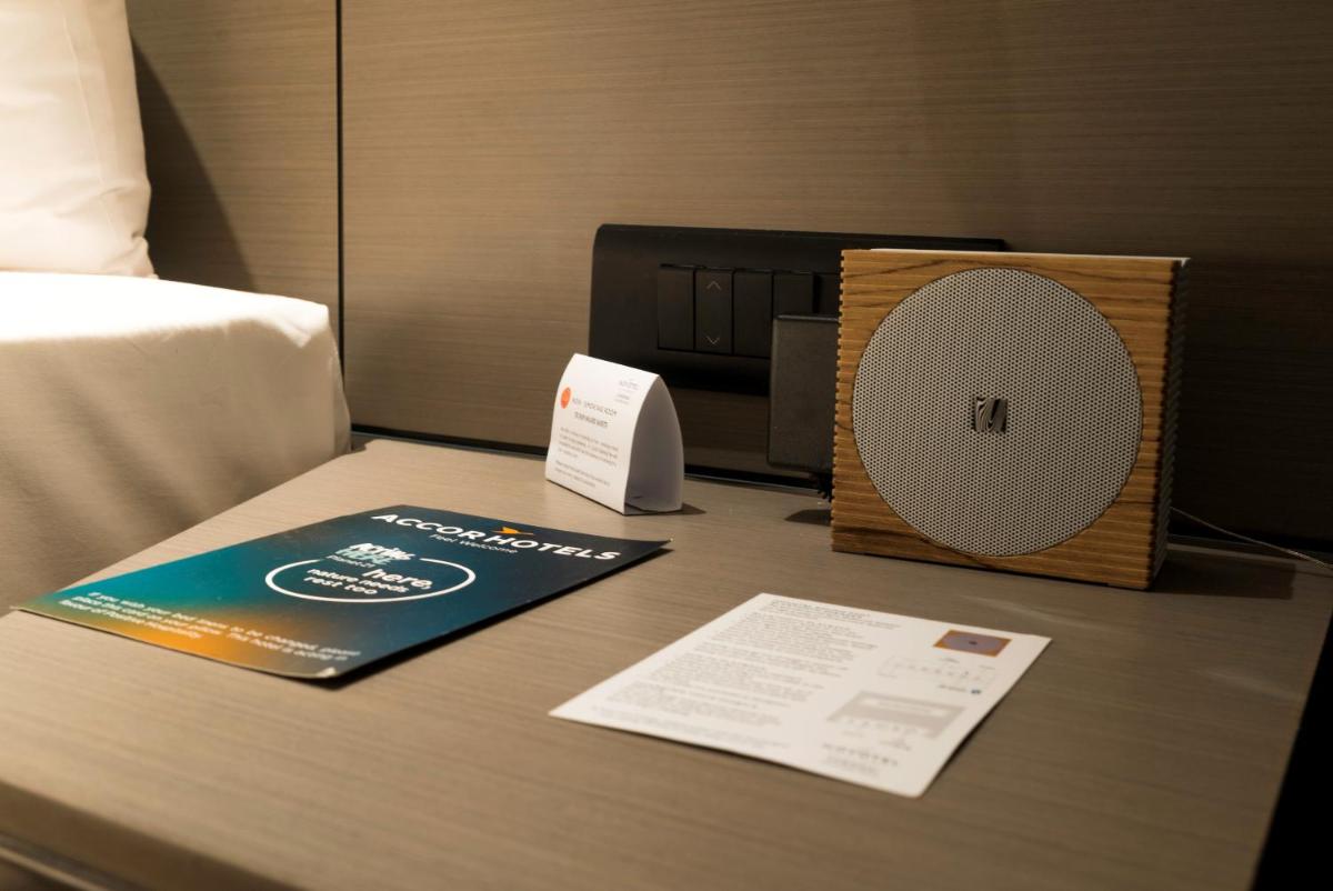 a desk with a book and a speaker on a table at Novotel Chennai Chamiers Road in Chennai