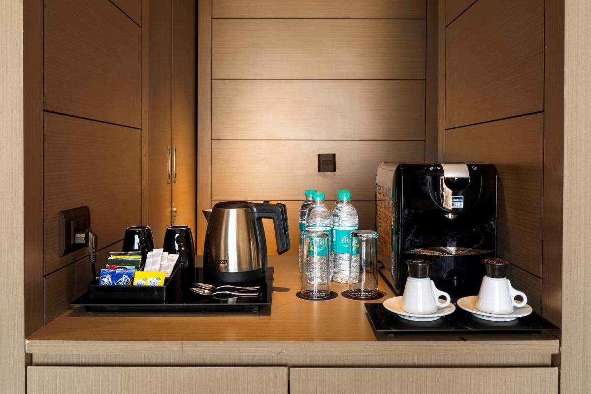 a coffeemaker and coffee maker sitting on a counter at Novotel Chennai Chamiers Road in Chennai