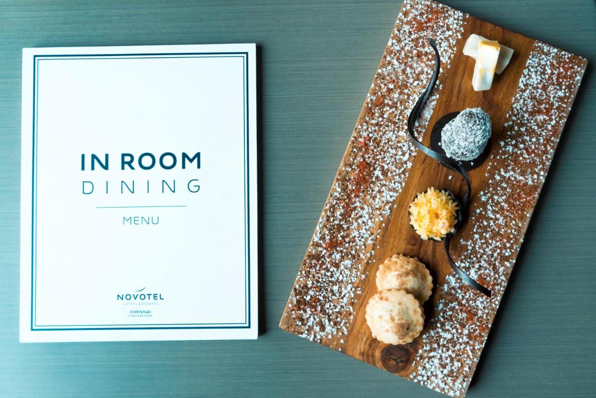 a book sitting next to a plate of food at Novotel Chennai Chamiers Road in Chennai