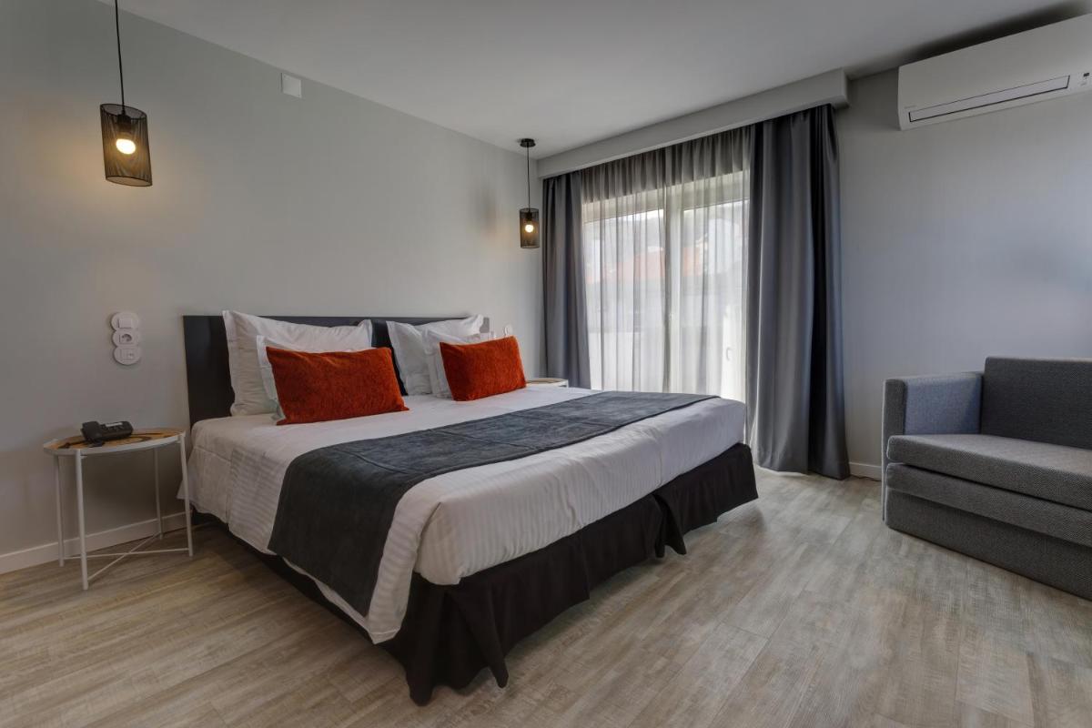um quarto com uma cama grande e um sofá em Sport Hotel Gym + SPA na Covilhã