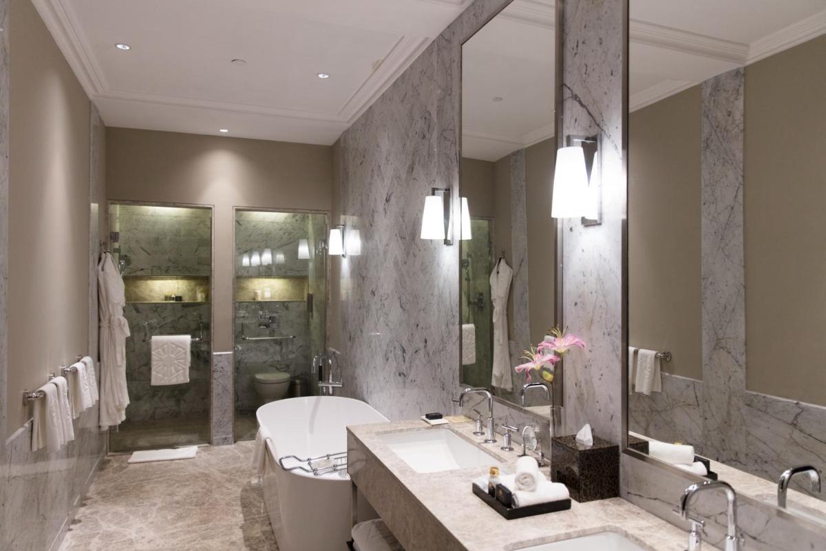 a bathroom with two sinks and a tub and a shower at Taj Connemara, Chennai in Chennai