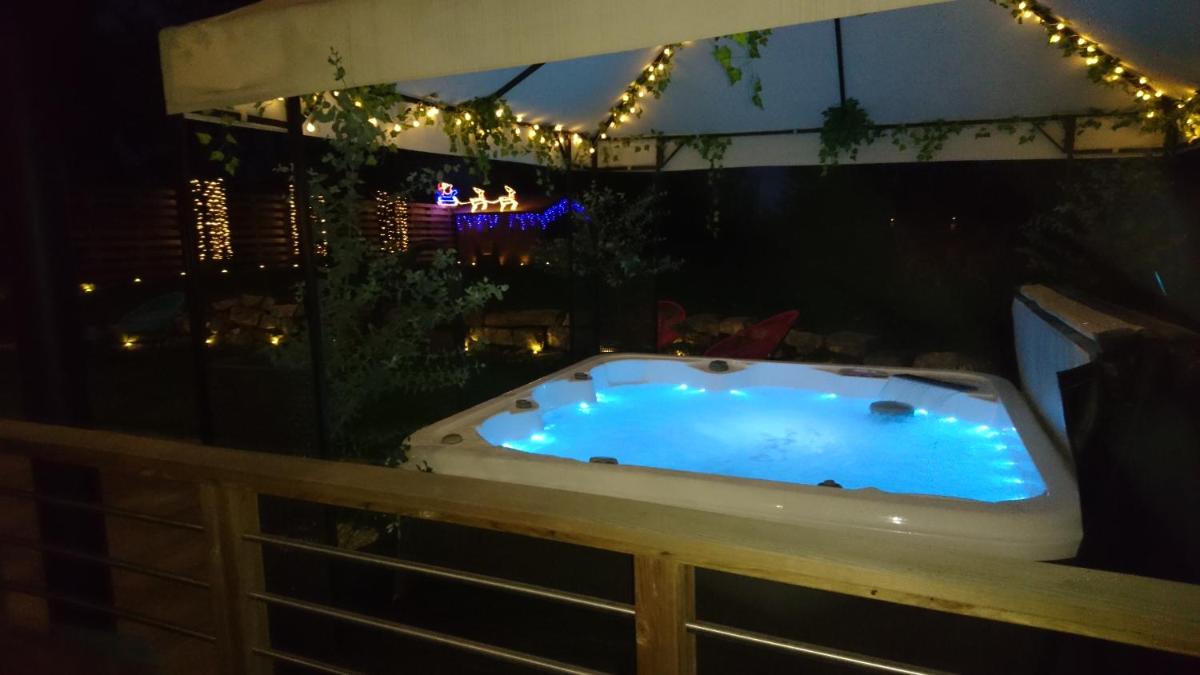 un jacuzzi dans un jardin la nuit dans l'établissement Le Moulin d'Oscar & Spa - Mulhouse Nord, à Baldersheim