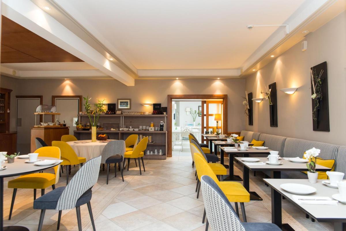 une salle à manger avec des tables et des chaises jaunes dans l'établissement Hôtel Lutétia & Spa, à La Baule 37 autres photos
