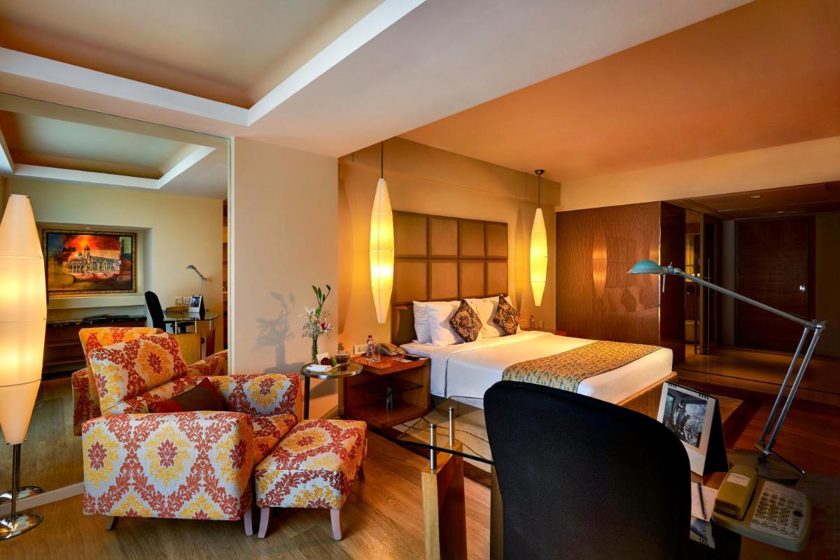a hotel room with a bed and a chair at Taj Club House in Chennai