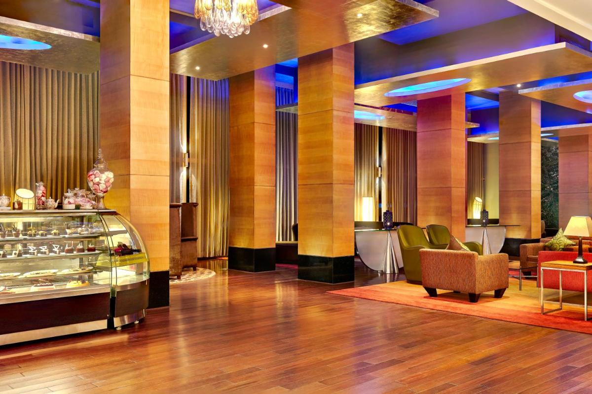 a lobby of a hotel with chairs and tables at Taj Club House in Chennai