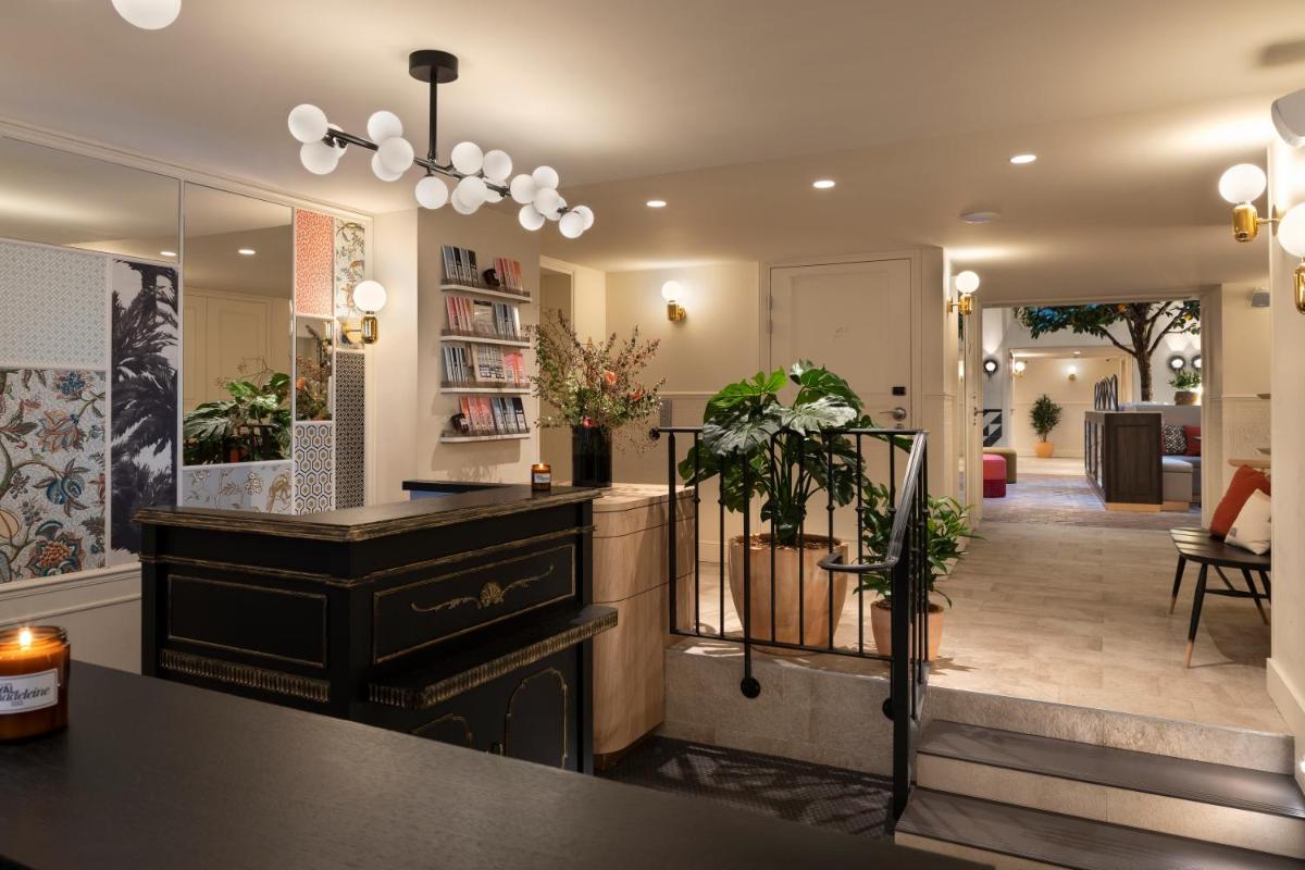 un hall d'entrée avec une commode noire et un couloir dans l'établissement Royal Madeleine Hotel & Spa, à Paris