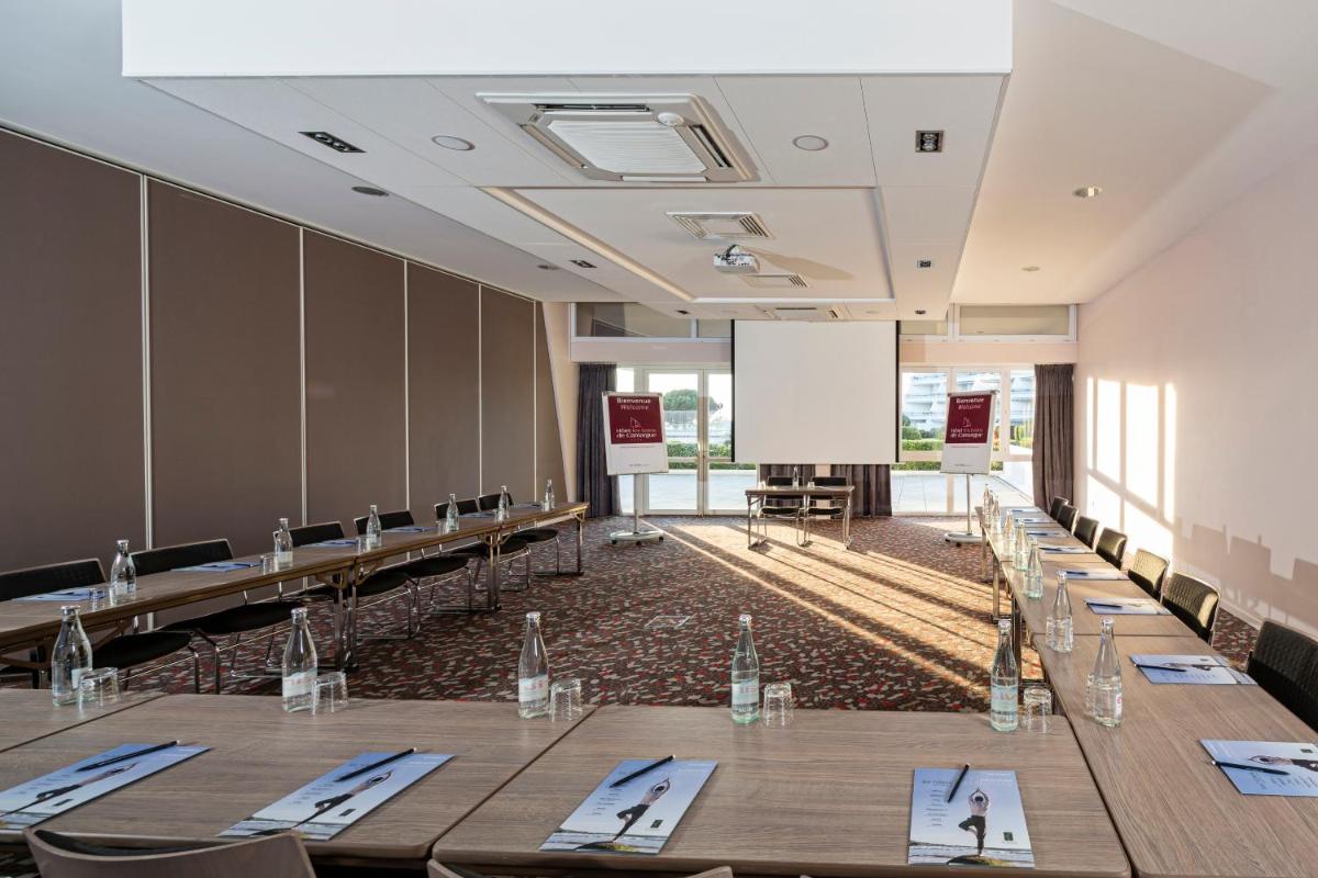 une salle de conférence avec des tables et des chaises et un tableau blanc dans l'établissement Thalazur Port-Camargue - Hotel & Spa, au Grau-du-Roi 77 autres photos
