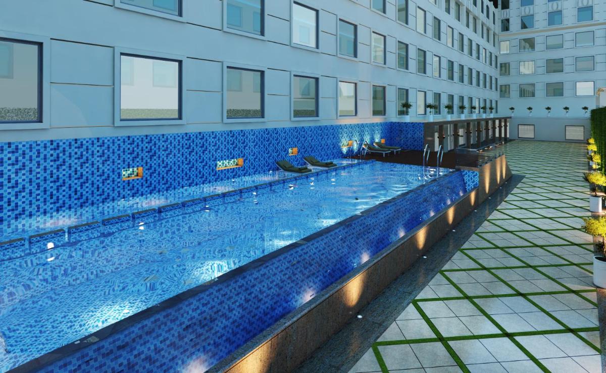 a large swimming pool in a building at Ramada by Wyndham Lucknow Hotel and Convention Center in Lucknow