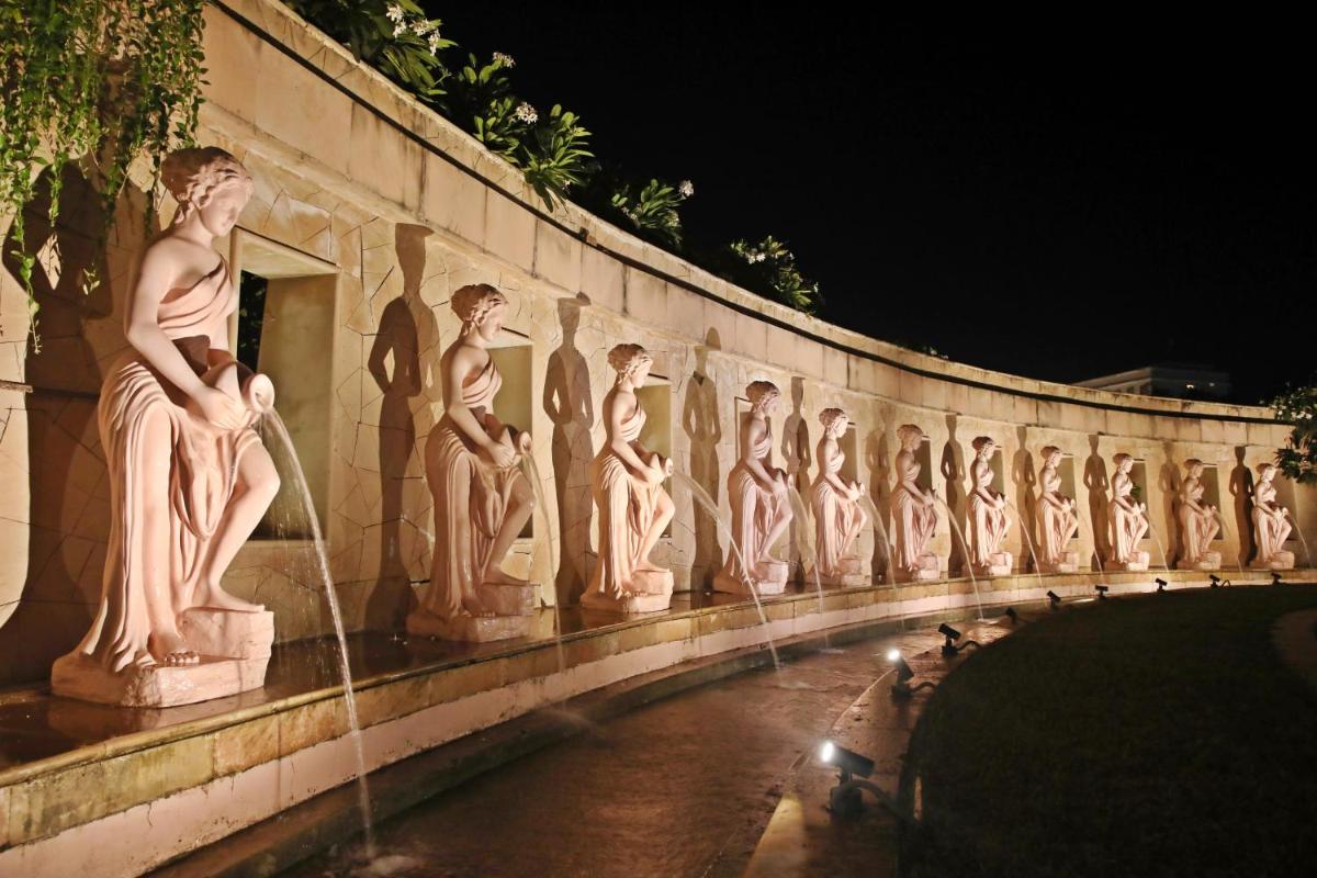 a wall with statues of women on it at Ramada by Wyndham Lucknow Hotel and Convention Center in Lucknow