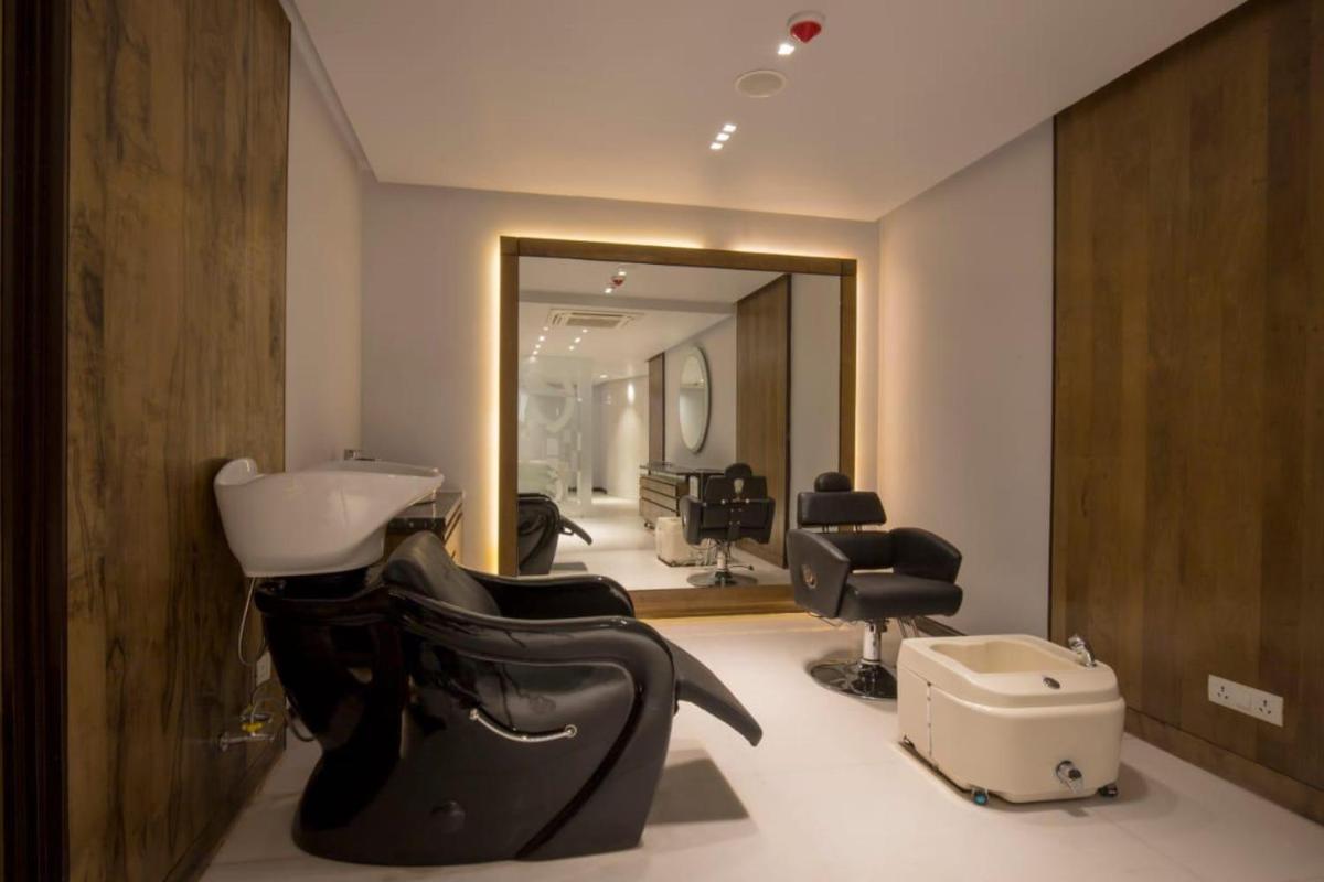 a hair salon with a bunch of hair chairs and a mirror at Zone By The Park Kolkata, Newtown in Kolkata +2 photos