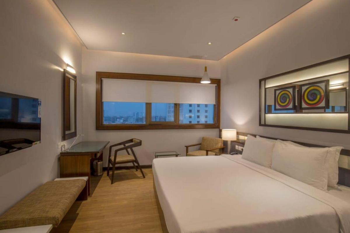 a bedroom with a bed and a desk and a table at Zone By The Park Kolkata, Newtown in Kolkata