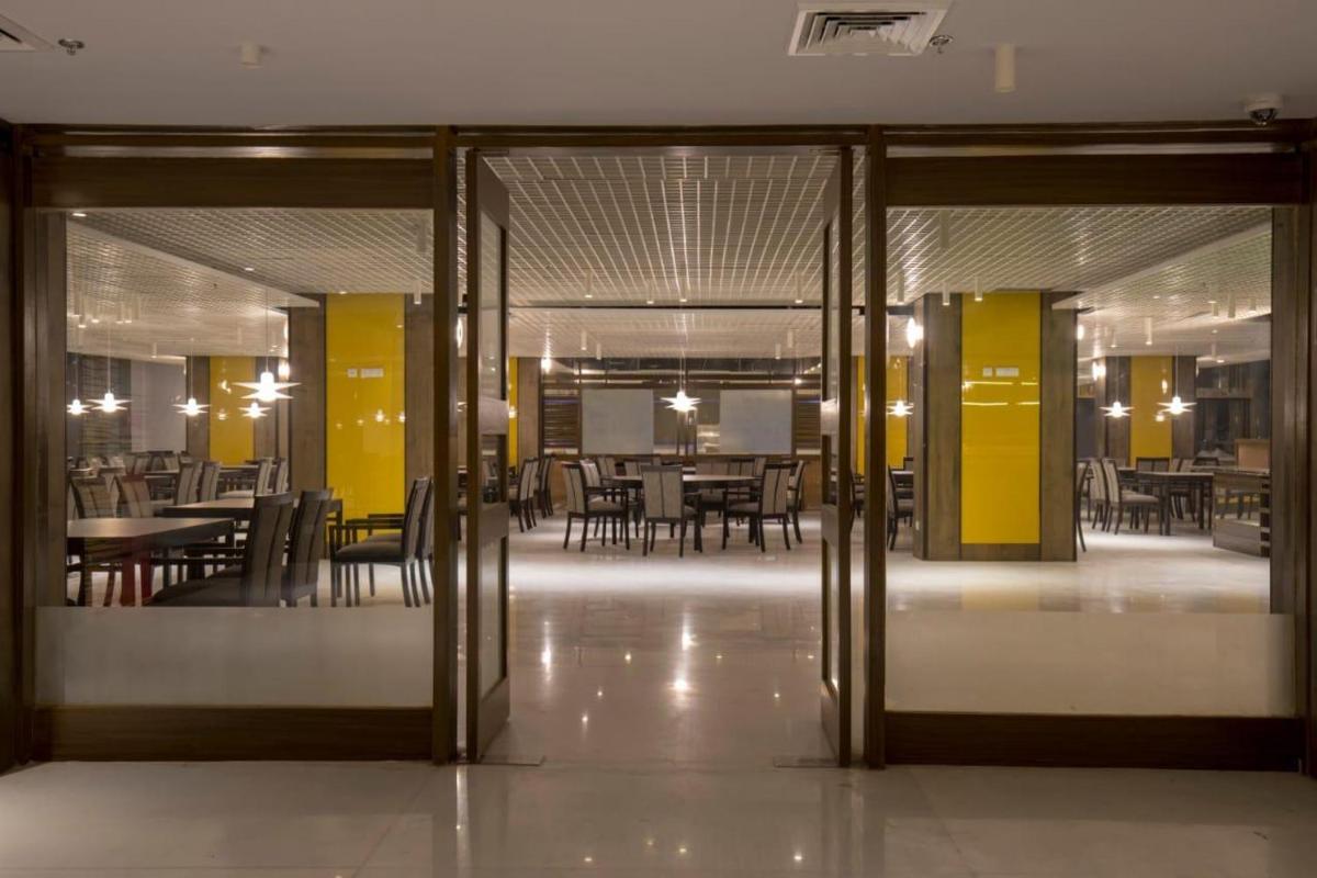 an open door to a dining room with tables and chairs at Zone By The Park Kolkata, Newtown in Kolkata