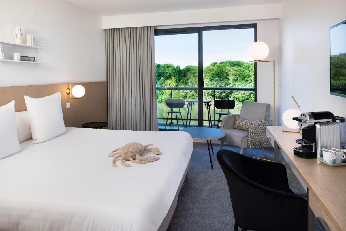une chambre d'hôtel avec un lit avec un animal farci dans l'établissement Best Western Plus Hotel les Rives du Ter, à Larmor-Plage