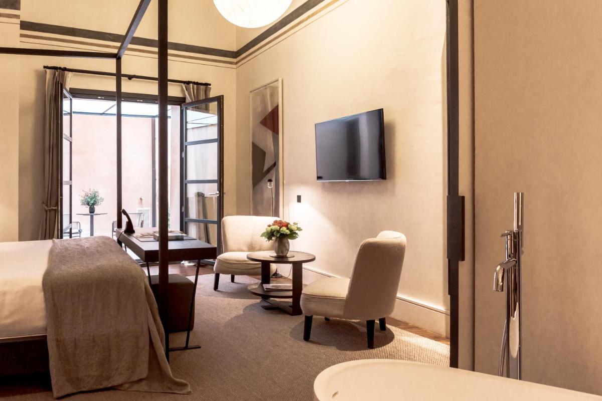 Una habitación de hotel con una cama, una mesa y sillas. en Sant Francesc Hotel Singular, en Palma de Mallorca