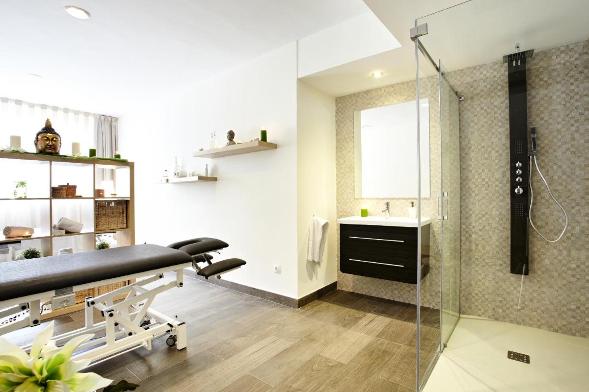 Baño principal con ducha y banco de masajes en Grupotel Montecarlo, en Can Picafort