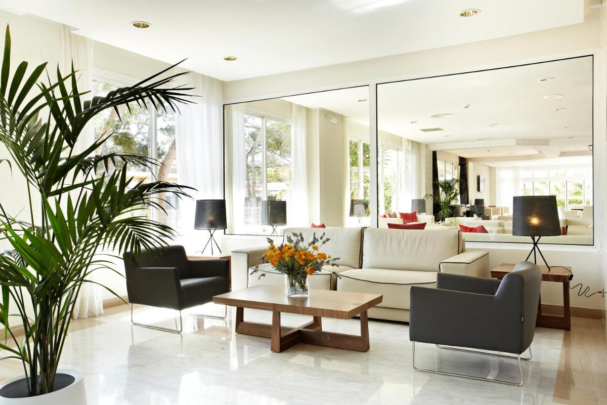 Una sala de estar con un sofá y sillas y una mesa. en Grupotel Montecarlo, en Can Picafort