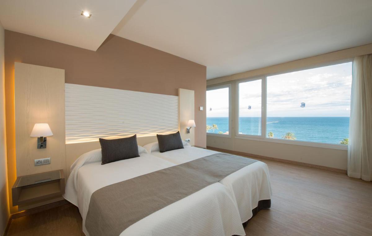 Un dormitorio con una cama grande con vista al mar. en HL Suitehotel Playa del Inglés - Adults Only, en Playa del Inglés