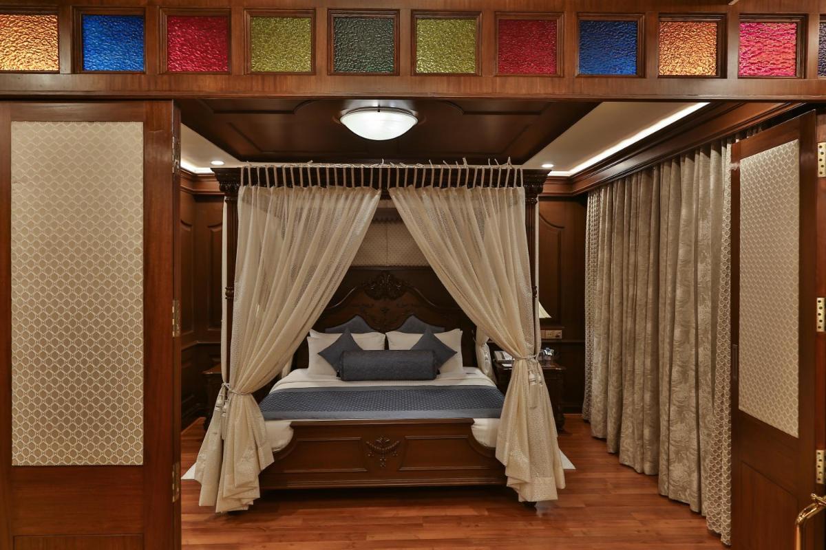 a bedroom with a canopy bed with curtains at The Accord Metropolitan in Chennai