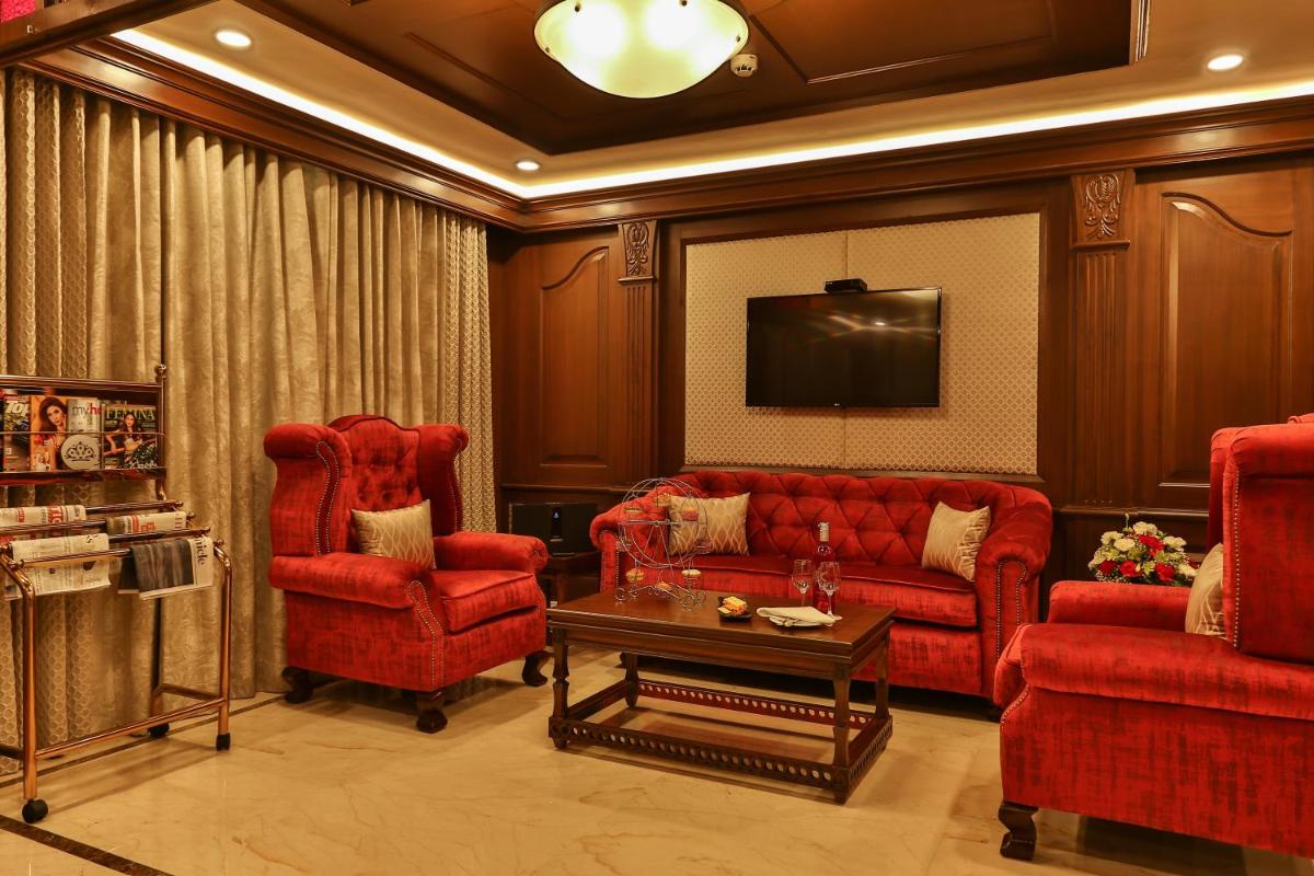 a living room with red furniture and a flat screen tv at The Accord Metropolitan in Chennai