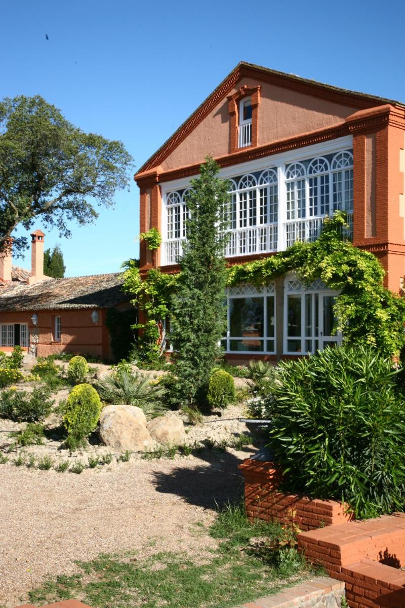 una casa con un jardín delante de ella en Hotel Valdepalacios Gourmand 5* GL, en Torrico
