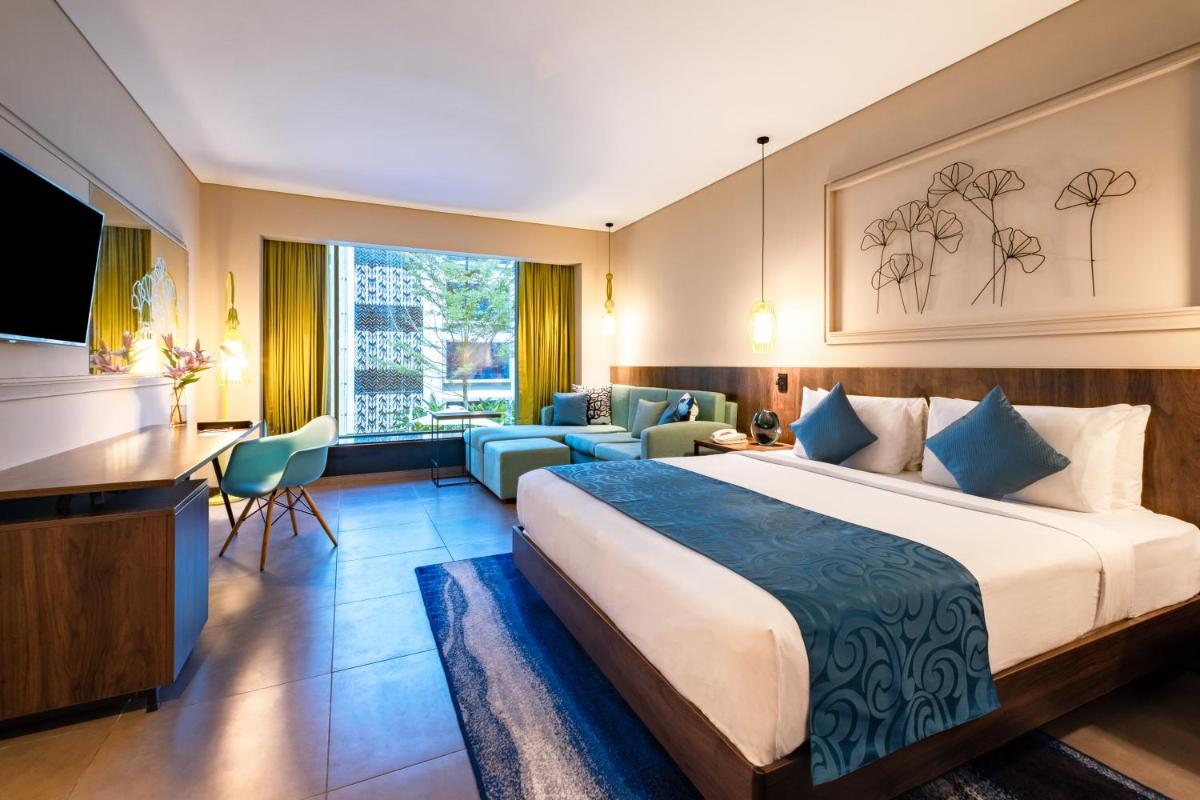 a hotel room with a bed and a desk at Hyatt Centric Candolim Goa in Calangute a hotel room with a bed and a desk at Hyatt Centric Candolim Goa in Calangute