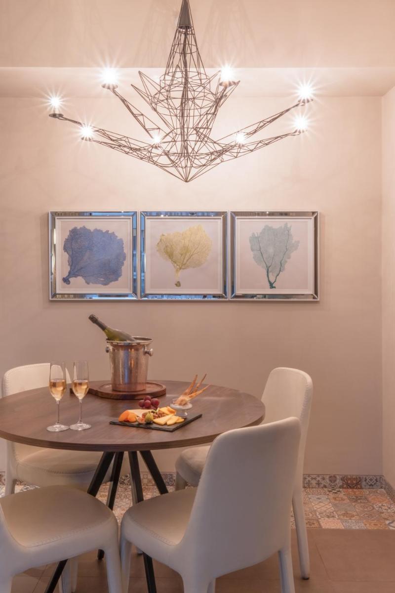 a dining room with a table and chairs and a chandelier at Hyatt Centric Candolim Goa in Calangute a dining room with a table and chairs and a chandelier at Hyatt Centric Candolim Goa in Calangute