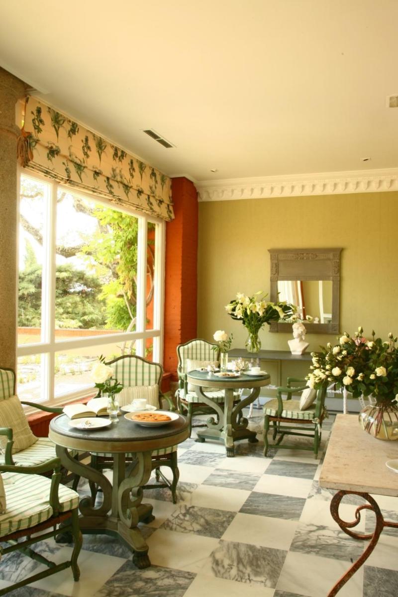 una sala de estar con mesas, sillas y una ventana en Hotel Valdepalacios Gourmand 5* GL, en Torrico