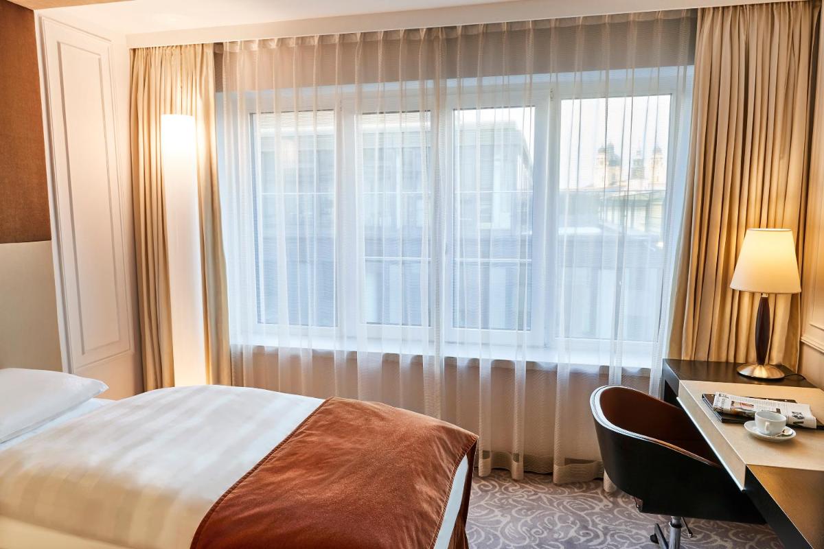 Ein Bett oder Betten in einem Zimmer der Unterkunft Vier Jahreszeiten Kempinski München