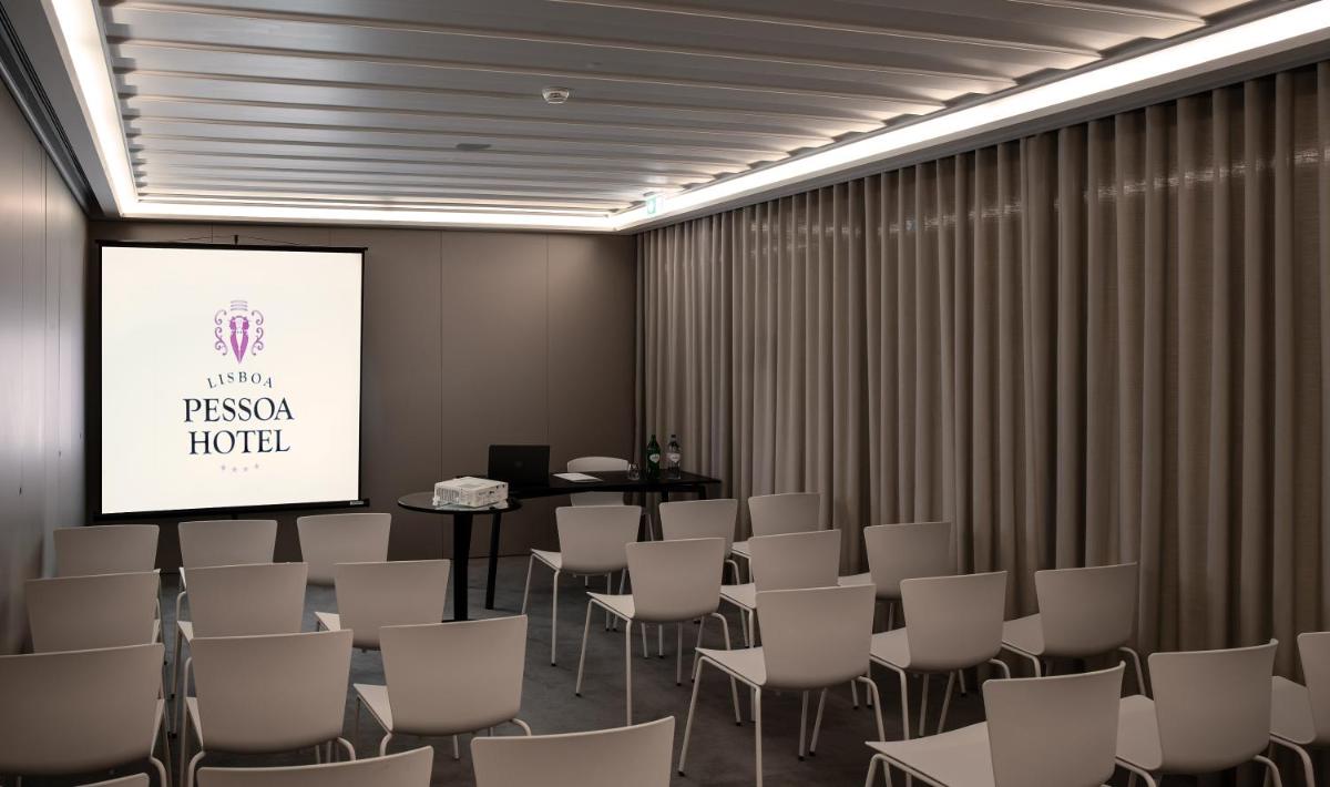 uma sala de conferências com tela e cadeiras em Lisboa Pessoa Hotel em Lisboa mais 114 fotografias