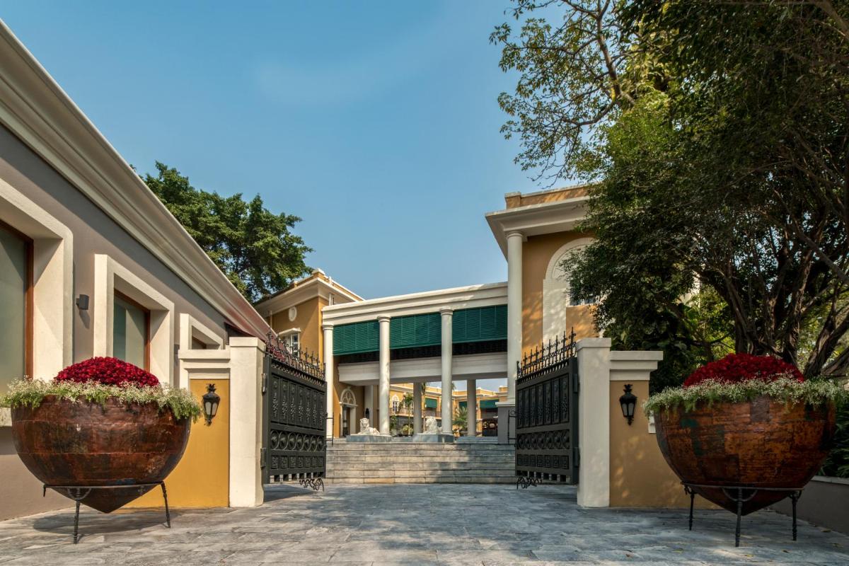 a building with two large flower pots in front of it at Raajkutir - IHCL SeleQtions in Kolkata