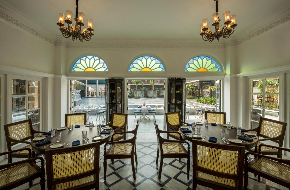 a dining room with a table and chairs and windows at Raajkutir - IHCL SeleQtions in Kolkata