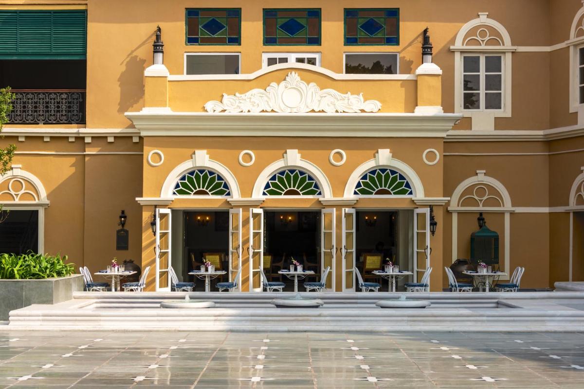 a building with tables and chairs in the courtyard at Raajkutir - IHCL SeleQtions in Kolkata
