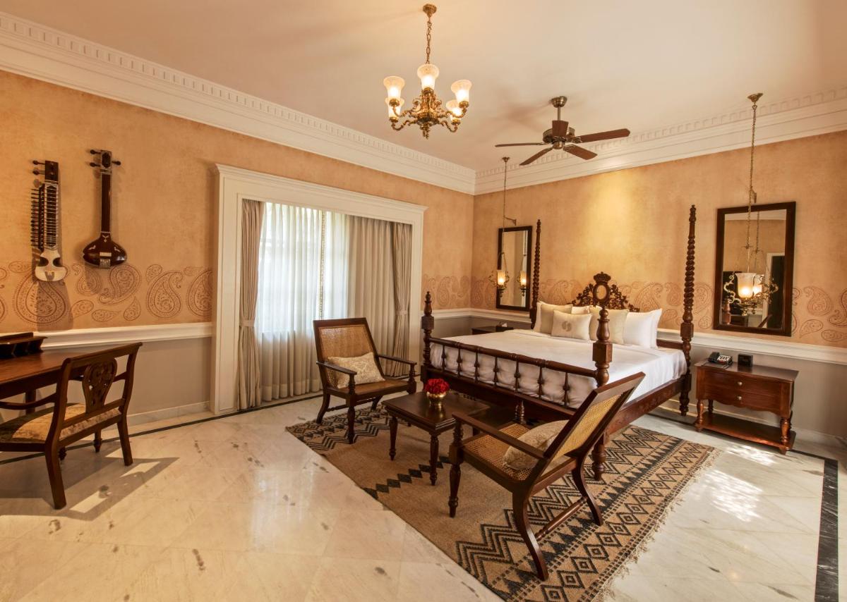 a bedroom with a bed and a table and chairs at Raajkutir - IHCL SeleQtions in Kolkata