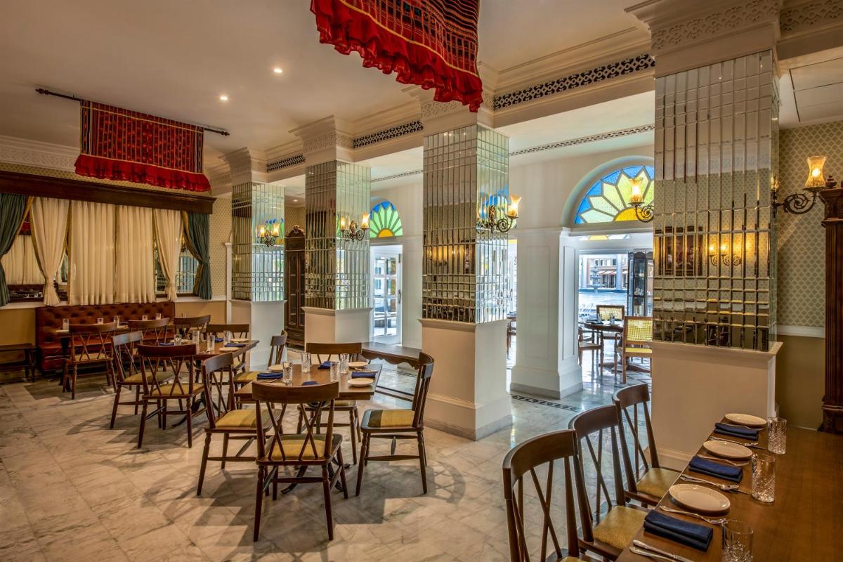 a restaurant with tables and chairs and a window at Raajkutir - IHCL SeleQtions in Kolkata