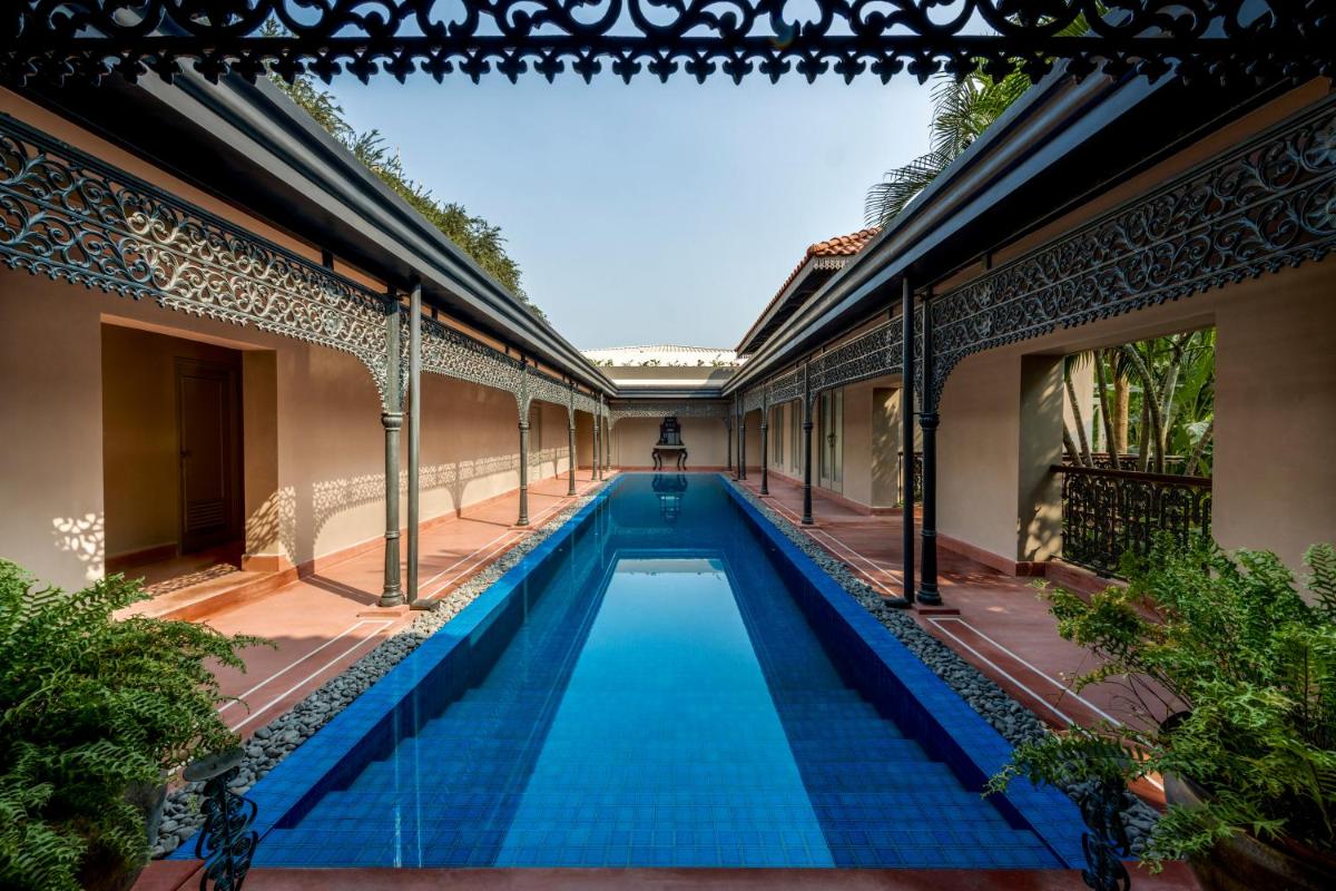 a swimming pool in the middle of a building at Raajkutir - IHCL SeleQtions in Kolkata a swimming pool in the middle of a building at Raajkutir - IHCL SeleQtions in Kolkata