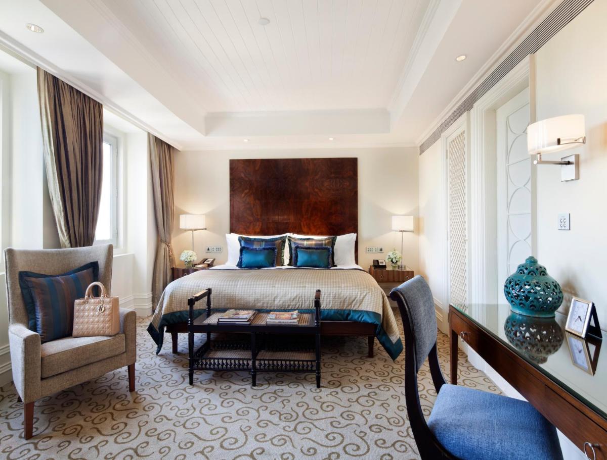 a bedroom with a bed and a desk and a chair at The Taj Mahal Palace, Mumbai in Mumbai a bedroom with a bed and a desk and a chair at The Taj Mahal Palace, Mumbai in Mumbai