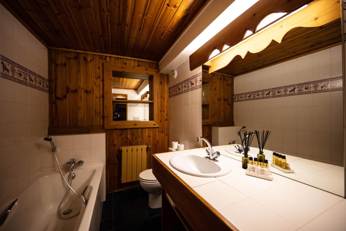 une salle de bain avec un lavabo, une baignoire et des toilettes dans l'établissement La Savoyarde, à Val dʼIsère 61 autres photos