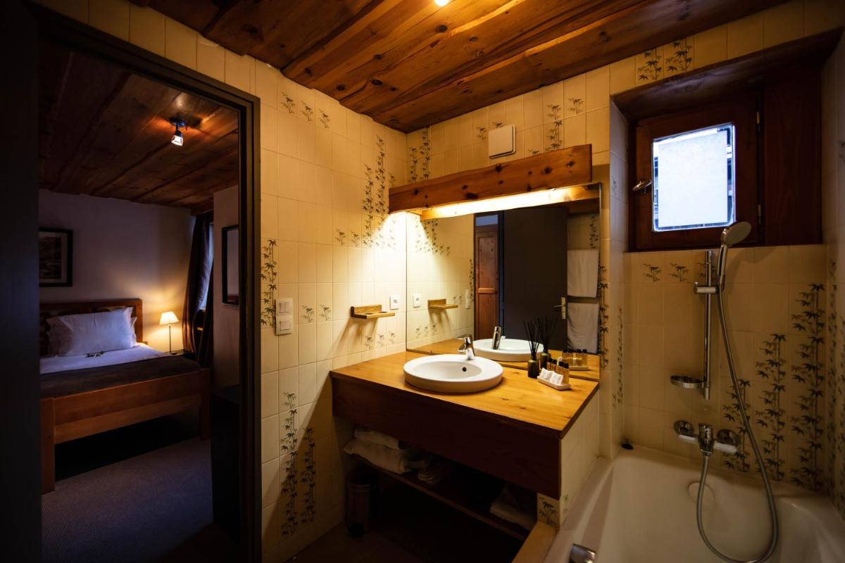 La salle de bains est pourvue d'un lavabo et d'un lit dans la chambre. dans l'établissement La Savoyarde, à Val dʼIsère