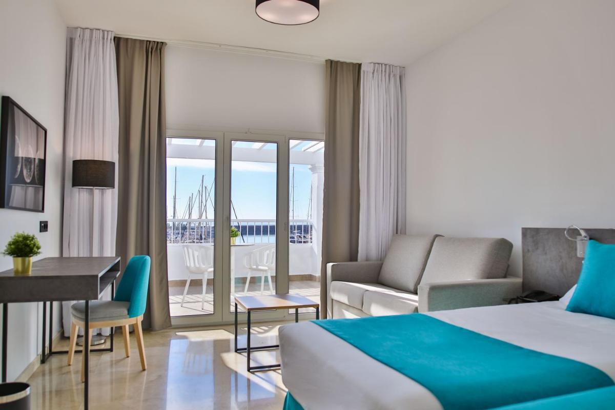 Una habitación de hotel con una cama y una sala de estar. en Moon Hotel & SPA., en Aguadulce