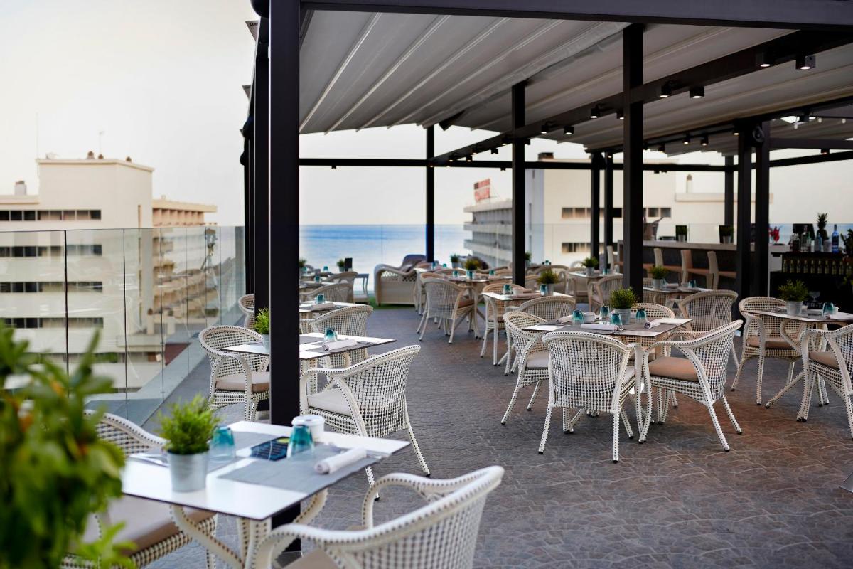 una fila de mesas y sillas en un balcón en Fénix Torremolinos - Adults Only Recommended, en Torremolinos
